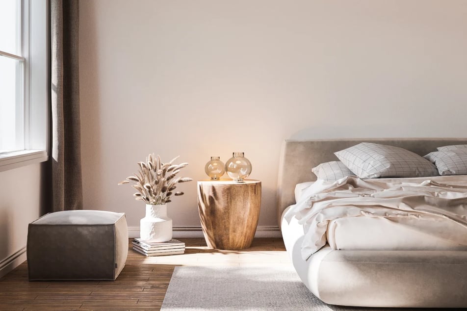Sypialnia w stylu skandynawskim. Pień jako stolik nocny wraz z lampami w kształcie kuli stojący obok białego wazonu.