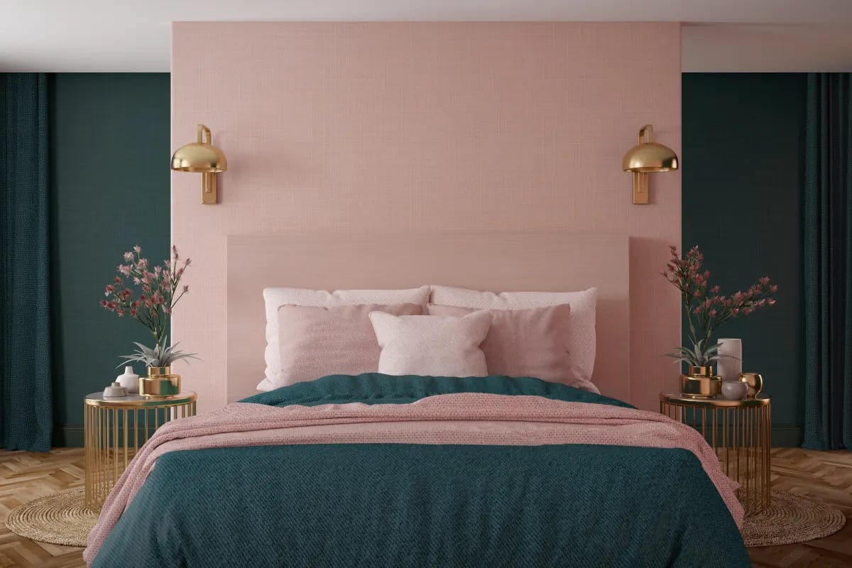 Sypialnia z różową ścianą. Narzuta oraz poduszki w kolorze różowym oraz zielonym. 