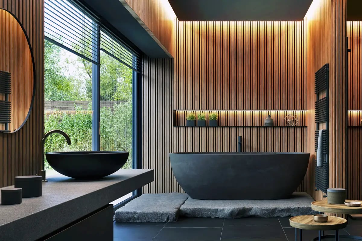 Łazienka z wykorzystaniem płytek imitujące lamele drewniane. Wanna, umywalka, armatura oraz dekoracje w kolorze czarnym.