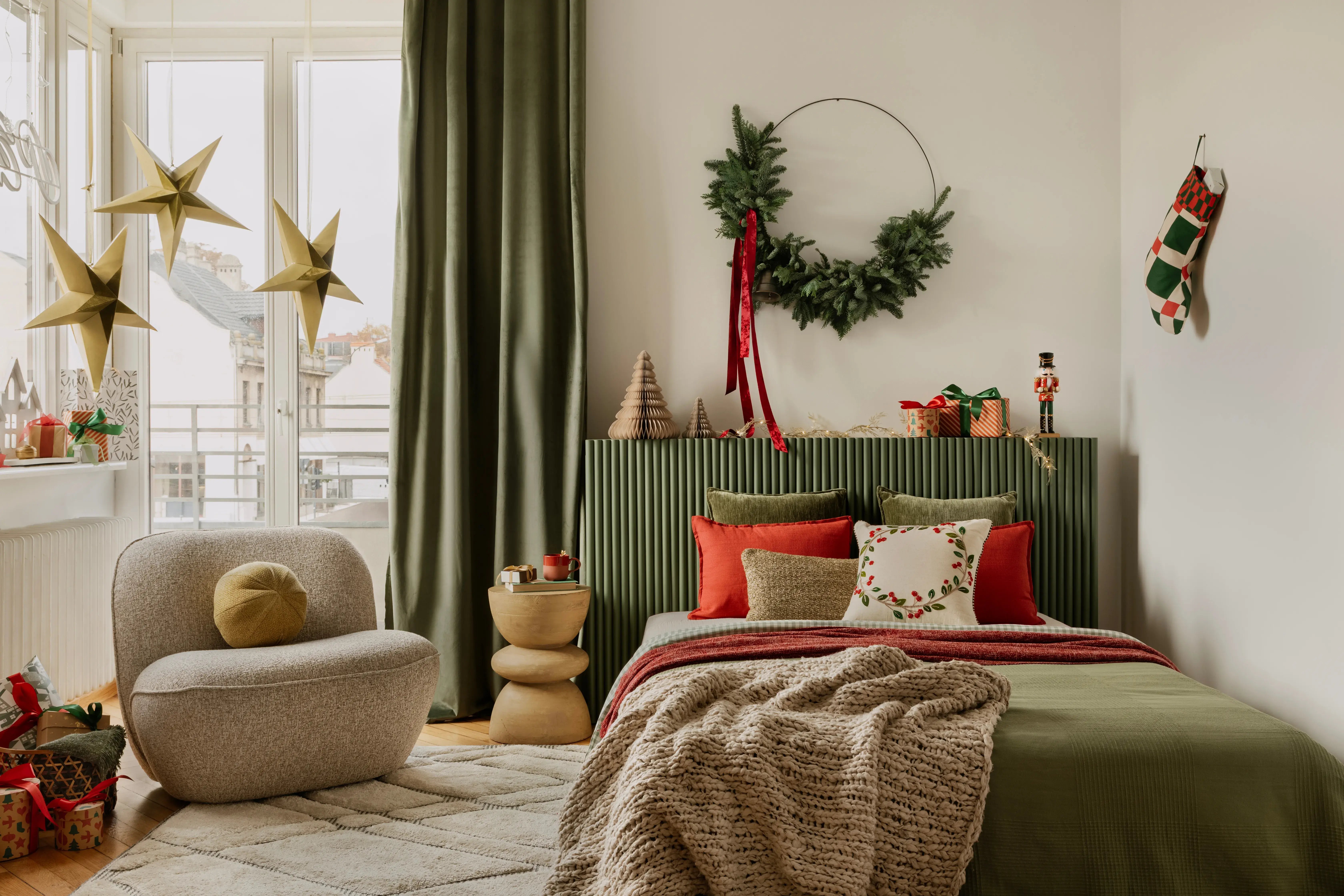 Pokój dziecka w stylu japandi przyozdobiony na święta Bożego Narodzenia, jak pościel, wieniec i gwiazdki zwisające z sufitu.