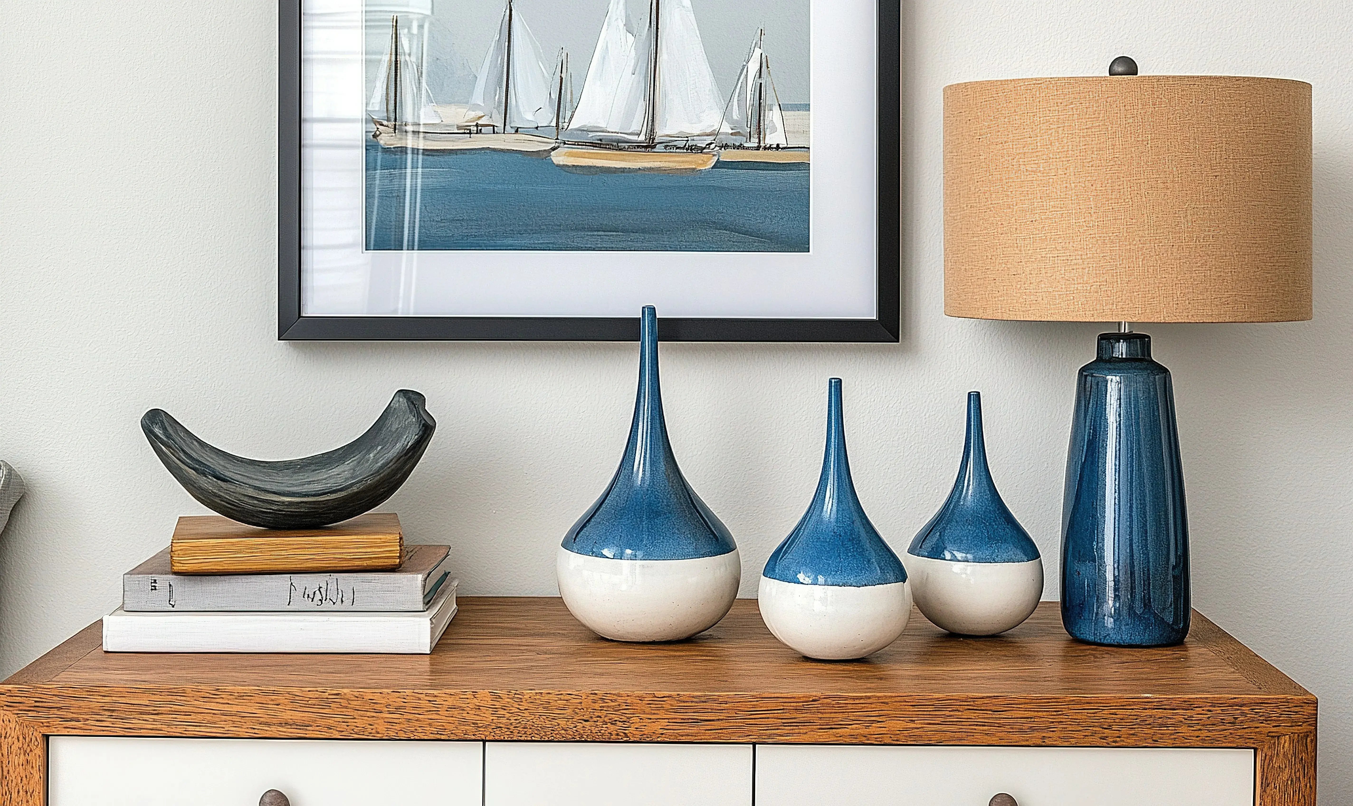 Salon w stylu marynistycznym z komodą, lampą i wazonami w niebieskim kolorze.