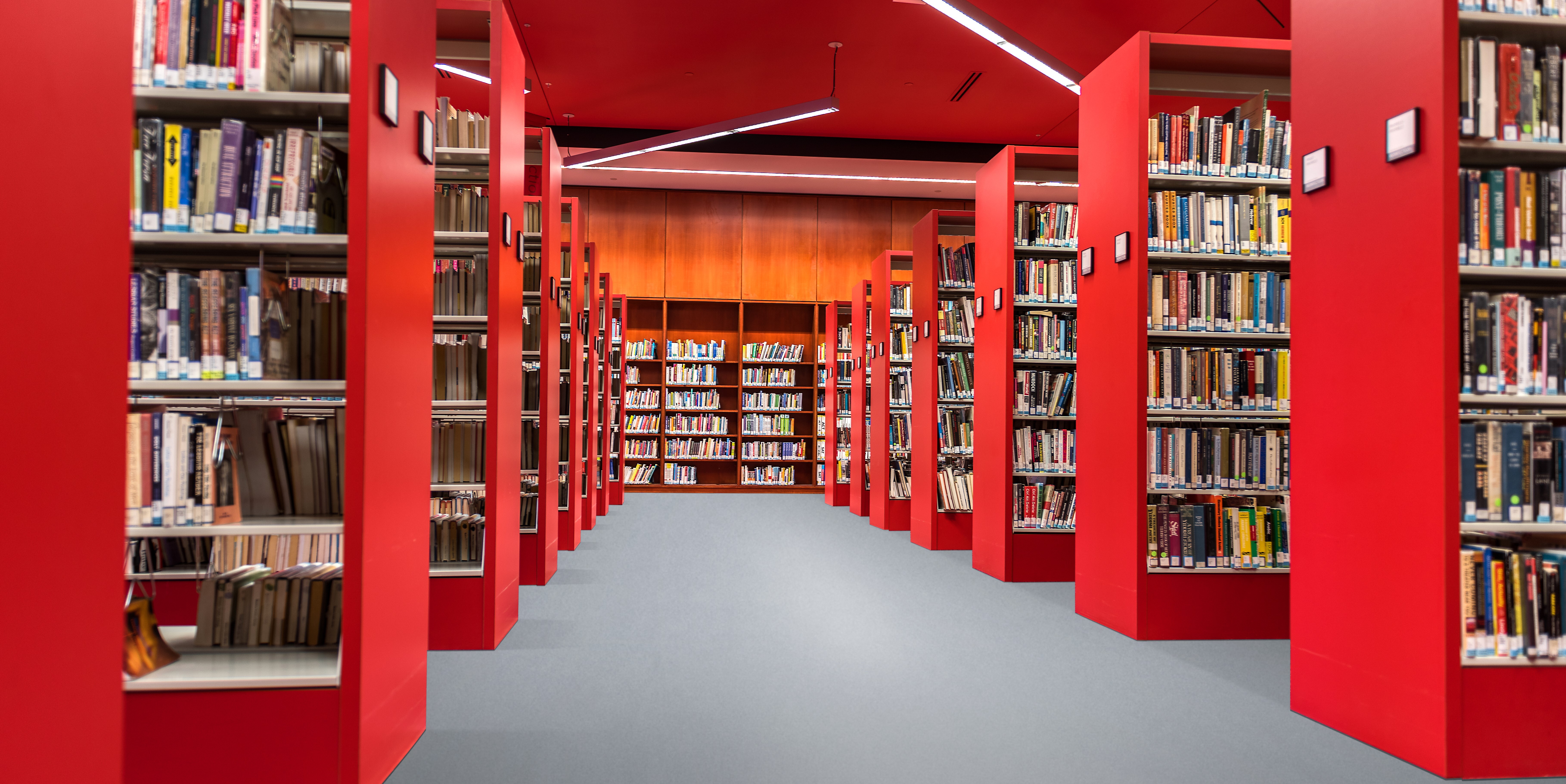 Czerwona biblioteka z dużą ilością książek zrobiona z płyt ognioodpornych.