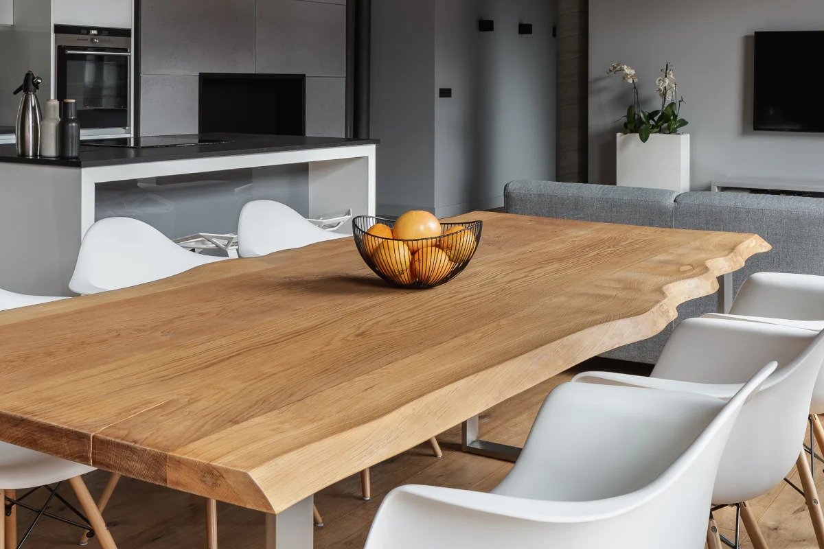 Stół z drewnianym blatem. Misa z owocami na środku.