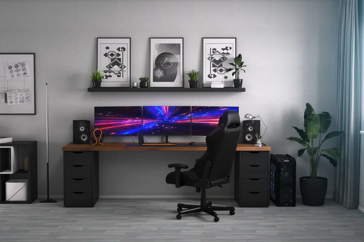 Pokój gamingowy z biurkiem z trzema monitorami oraz innymi akcesoriami.